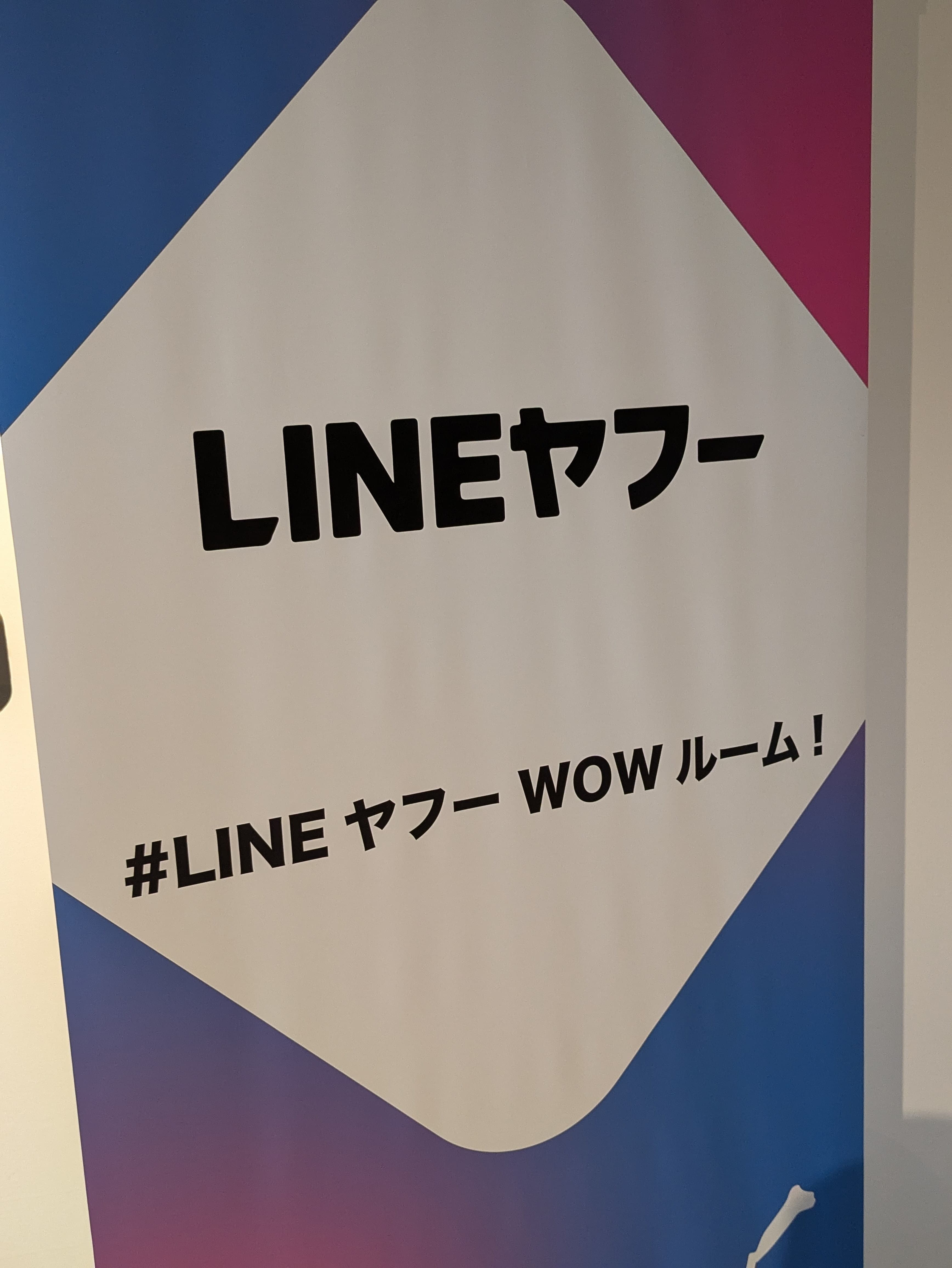 垂れ幕に「LINEヤフー #LINEヤフーWOWルーム」という文字が書かれている