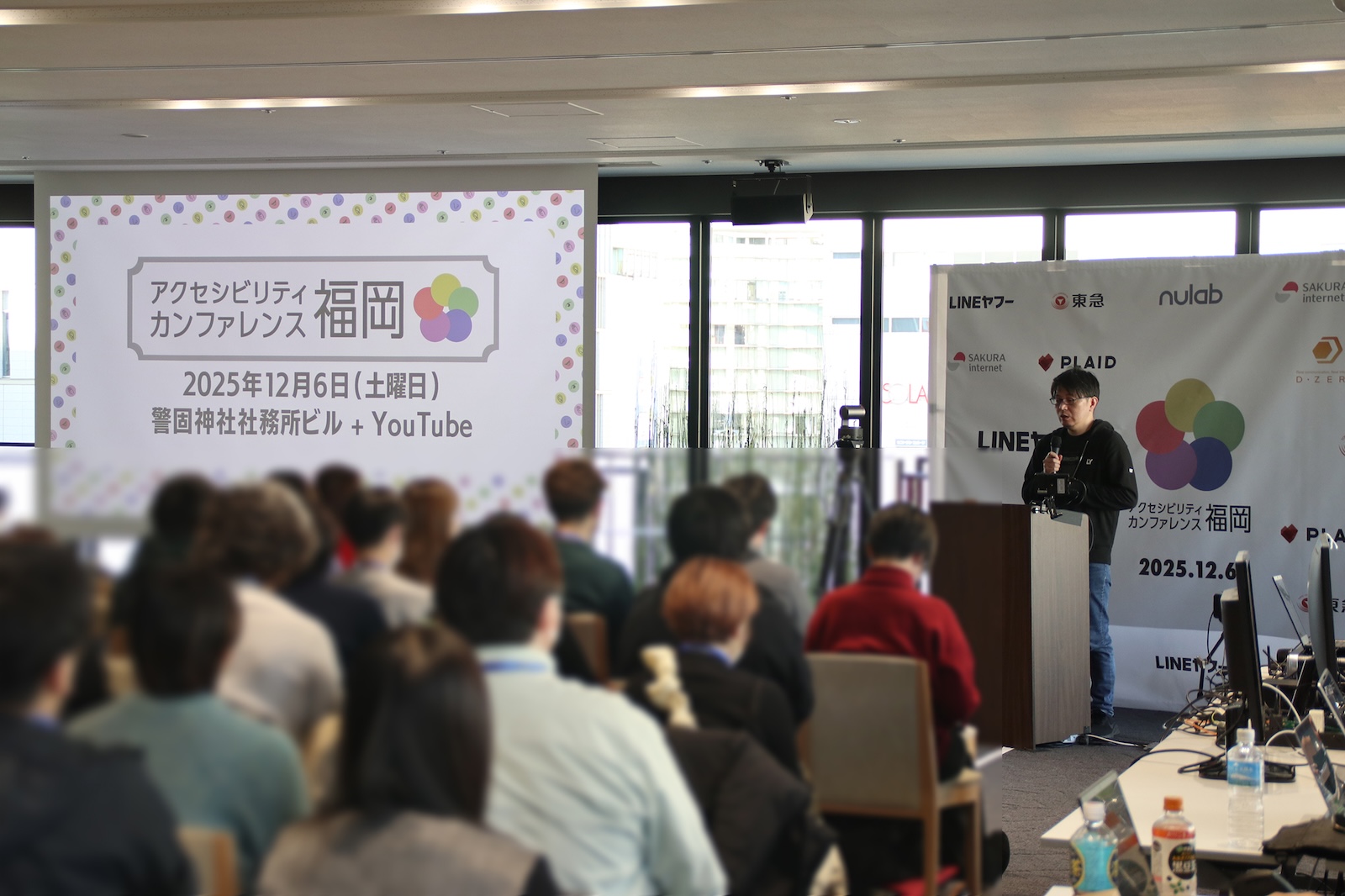 スポンサーセッション時の場内全体を写した写真。手前は参加者が座っており、奥ではLINEヤフー富田が登壇している。